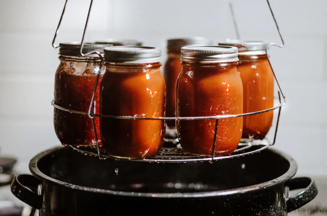 Filled jars lifted from a canning pot